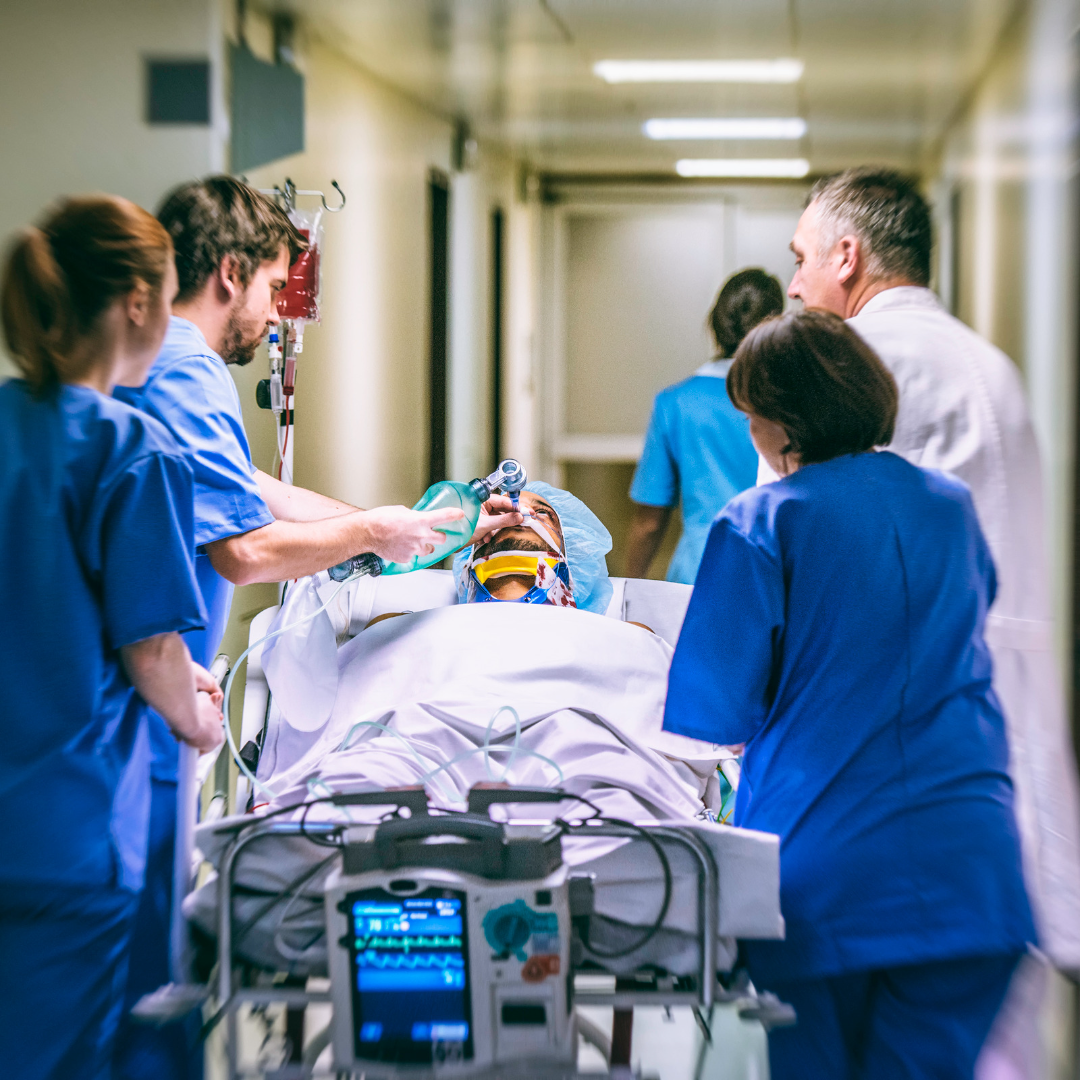 Doctors and nurses around a man on a gurney