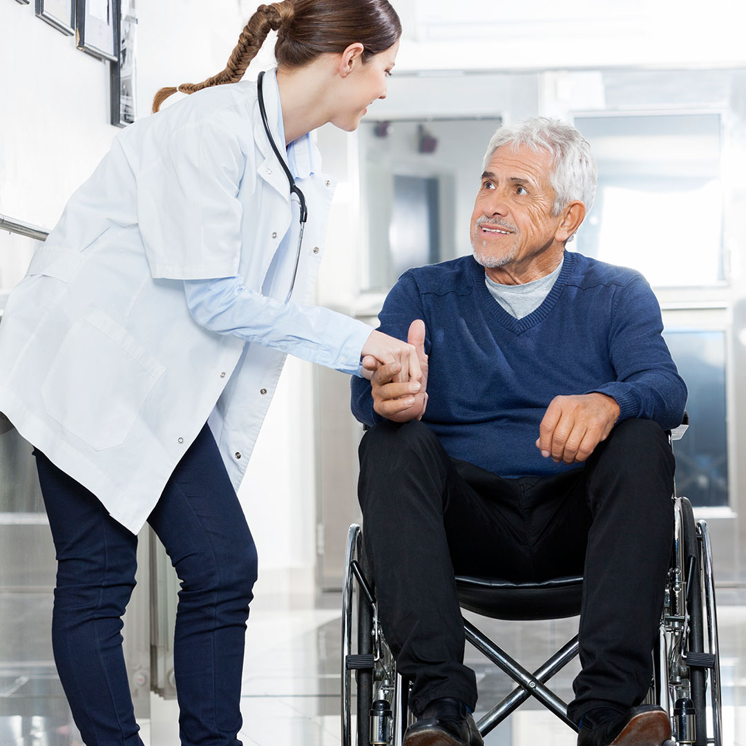 doctor shaking hands with senior in wheelchair