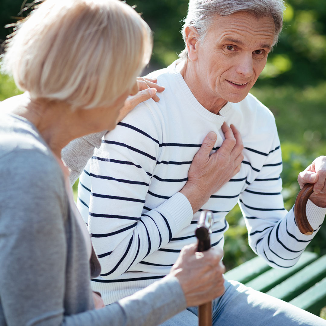 woman and man holding chest in pain